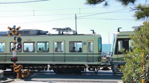 鎌倉高校前駅〜七里ケ浜駅間の踏切を走る江ノ島電鉄の車両