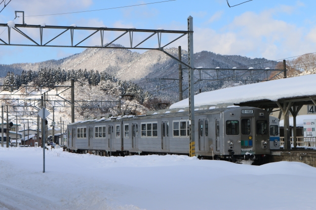 雪が積もる大鰐駅に到着する弘南鉄道大鰐線7000系電車