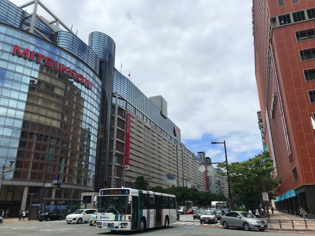 西鉄福岡(天神)駅ビルと渡辺通りを走る西鉄バス(写真AC/らびっこ)