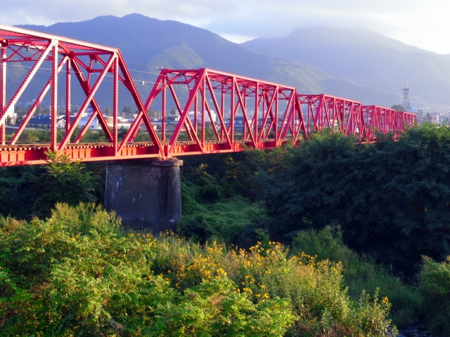 「赤い鉄橋」として親しまれている上田電鉄別所線の千曲川橋梁(写真AC/玄太)