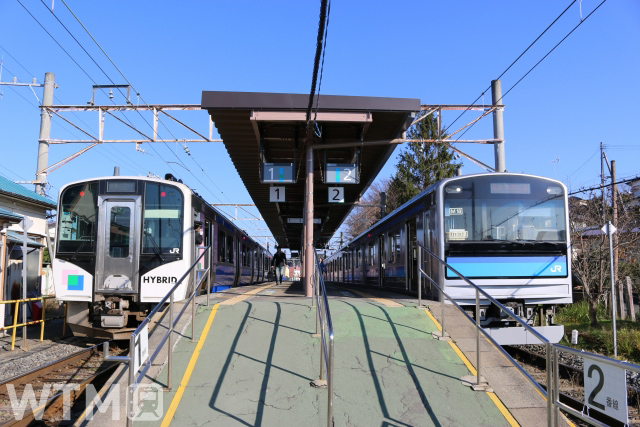 仙石線高城町駅に停車中のJR東日本HB-E210系気動車(左)と205系3100番台電車(PhotoNetwork/写真AC)